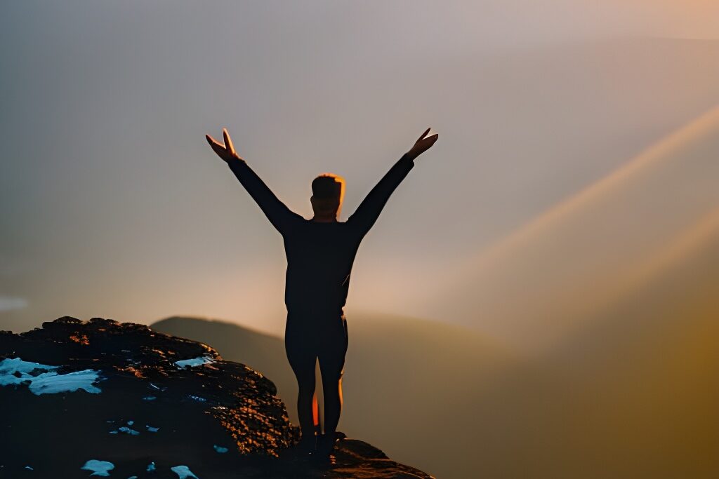  a person standing atop a mountain, arms raised triumphantly, bathed in the golden light of a sunrise, finding hope