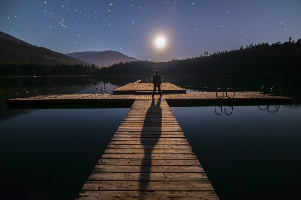 Silhouette of Person Standing on Bridge