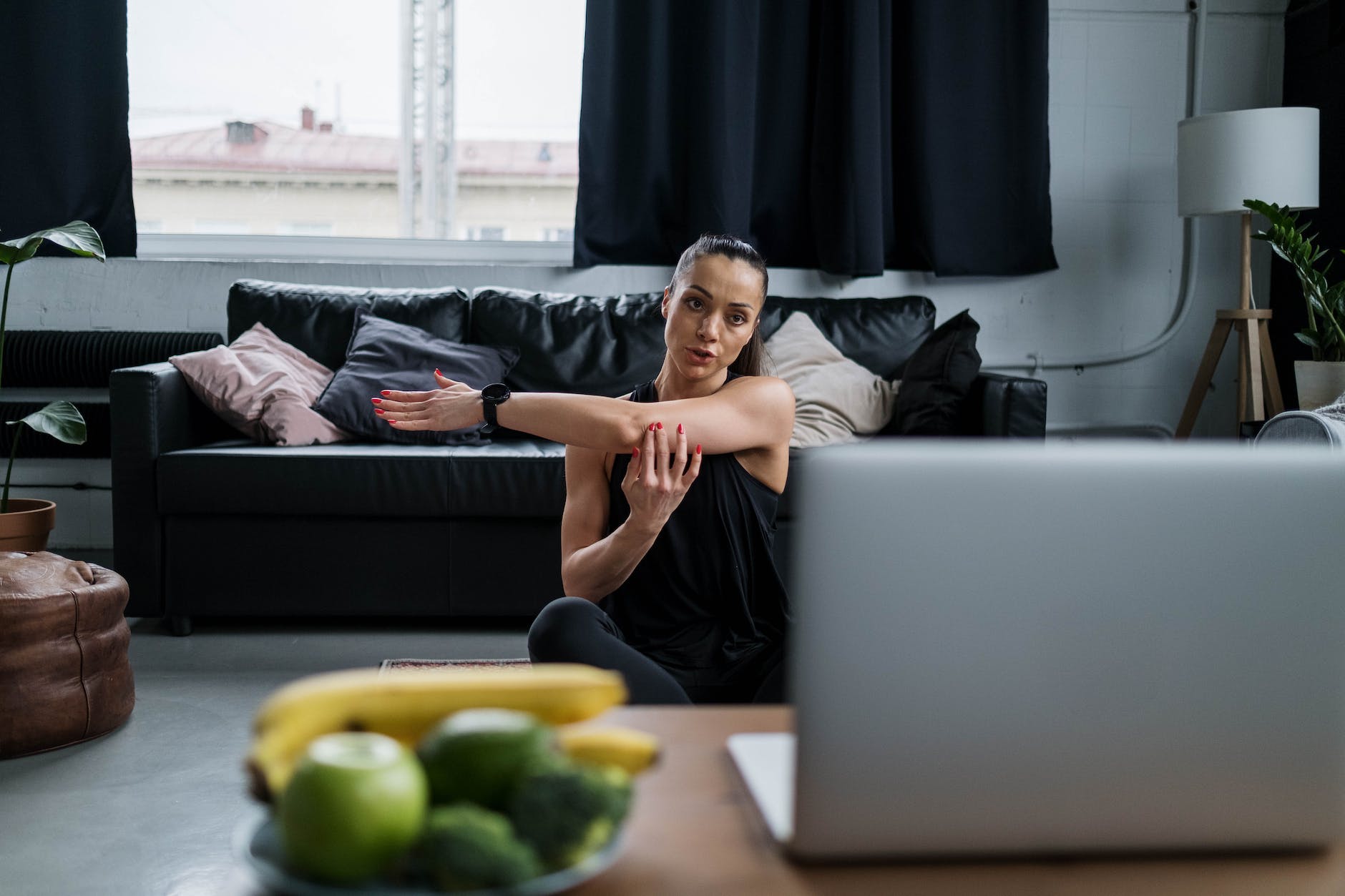 Woman in Black Tank Top Stretching Her Arm thinking about Power of Positive Affirmations